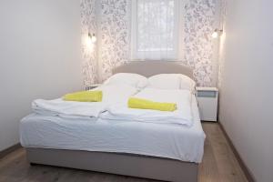 ハイドゥソボスローにあるZoli Apartmanok-Timi Kölcsey 34-36の白いベッド(黄色い枕2つ付)