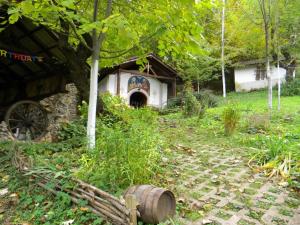 una vieja casa con un barril delante de ella en Balkanski chanove, en Botevgrad