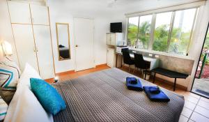 a bedroom with a bed with blue items on it at Central Motel Gin Gin in Gin Gin