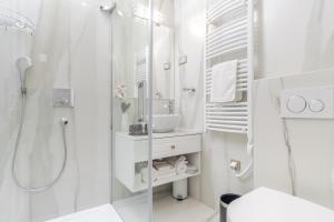 a white bathroom with a shower and a sink at Ann Luxury Rooms in Split