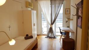 アテネにあるErrathens Apartments - Athens Centerのベッド、デスク、窓が備わる客室です。