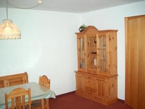 a dining room with a table and a wooden cabinet at Haus Salzgeber Angelika in Schruns-Tschagguns