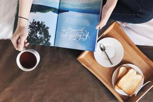 a book on a table with bread and a cup of coffee at The Lively Hotel Kualanamu in Medan