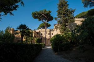 un gran edificio con árboles delante de él en Villa Angelina, en Roma