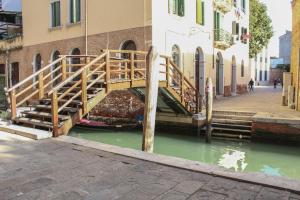 a wooden bridge over a canal in a city at Centrale Mazzoni 15 in Venice