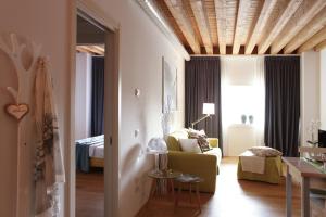 a living room with a yellow couch and a bed at Centrale Mazzoni 15 in Venice