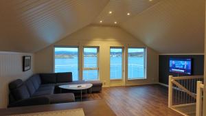 a living room with a couch and a tv at Saltstraumen Brygge in Saltstraumen