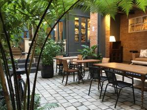 an outdoor patio with tables and chairs and plants at Hotel Noir in Chiang Mai