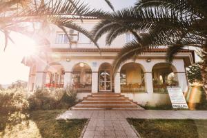 a house with a palm tree in front of it at Hostal La Dehesa in Villanueva del Rey