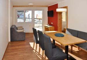 a dining room with a wooden table and chairs at Sölle Homes Nassfeld in Sonnenalpe Nassfeld