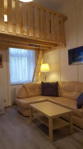 ein Wohnzimmer mit einem Sofa und einem Hochbett in der Unterkunft Ferienwohnung Roch GbR in Berlin