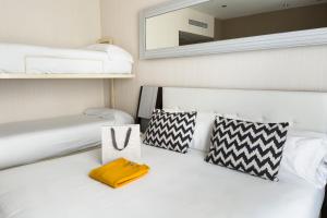 1 dormitorio con cama blanca y espejo en la pared en Petit Palace Triball en Madrid