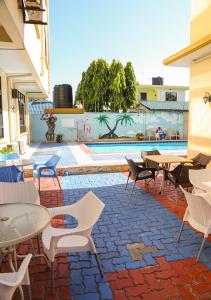 a patio with tables and chairs and a pool at Hotel de Mag (Plaza) in Dar es Salaam