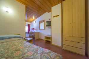 ein Schlafzimmer mit einem Bett und einem Schrank in einem Zimmer in der Unterkunft Hotel Trentino in Folgaria