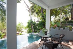 a patio with a table and chairs next to a swimming pool at Arawan Krabi Beach Resort in Ao Nam Mao