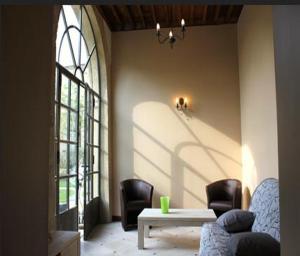 ペズナにあるLes Galeries de Beaulacのリビングルーム(椅子、テーブル付)、窓が備わります。
