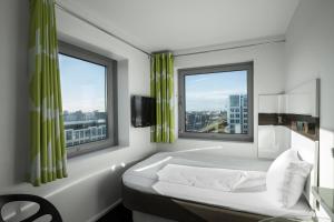 
a hotel room with a bed and a window at Wakeup Copenhagen - Carsten Niebuhrs Gade in Copenhagen
