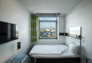 a small room with a bed and a window at Wakeup Copenhagen - Carsten Niebuhrs Gade in Copenhagen