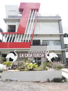 a building with two white birds in front of it at La Casa Teresa Tourist Inn Inc in El Nido