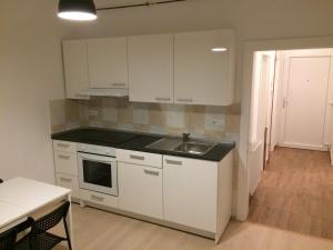 a kitchen with white cabinets and a sink and a table at apartma Delavska in Maribor