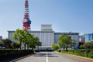 a street in front of a building with a red tower at Tokyo Prince Hotel in Tokyo
