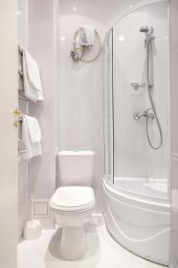 a white bathroom with a toilet and a shower at Zvezdniy in Tula