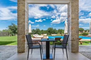 Veleniki丹妮拉住宿加早餐酒店的带桌椅和游泳池的露台