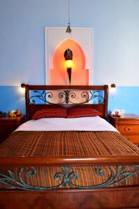 a bedroom with a bed with a lamp on it at Riad Ksar El Jadida Maroc in El Jadida