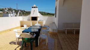 a balcony with a table and chairs and a lighthouse at Vila Ricardo by Sunny Deluxe in Albufeira