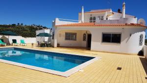 a villa with a swimming pool in front of a house at Vila Ricardo by Sunny Deluxe in Albufeira