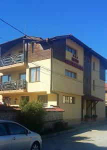 un bâtiment avec une voiture garée devant lui dans l'établissement Hotel Saint Nicola, à Banya