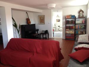 a living room with a red couch and a piano at AirPorto Hostel in Maia