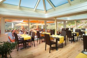 een eetkamer met tafels, stoelen en ramen bij Albtalblick Ihr Wellness- & Wanderhotel in Häusern