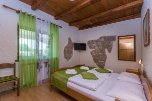 a bedroom with a large bed with green curtains at Bed & Breakfast Daniela in Veleniki
