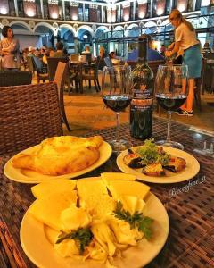 stół z talerzami jedzenia i kieliszkami wina w obiekcie Premium Class In Batumi w mieście Batumi