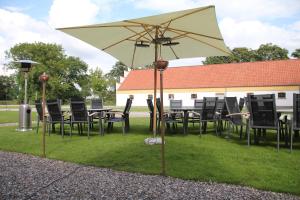 a table and chairs and an umbrella on the grass at Bramslevgaard in Hobro