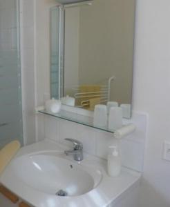 a white bathroom with a sink and a mirror at Chambres d'Hôtes Le Cadran Solaire in Cabrières
