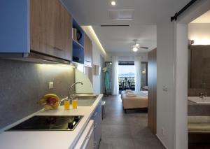 a kitchen with a sink and a living room at Locanda Barbati Luxury ApartHotel in Barbati