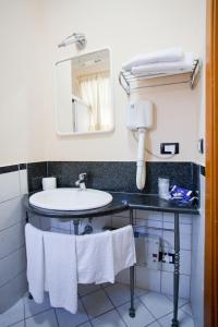 a bathroom with a sink and a mirror and towels at Hermitage Capua Hotel in Capua