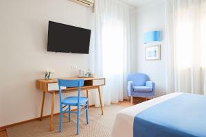 a bedroom with a desk and two chairs and a tv at La Serliana - Bed&Breakfast in Vicenza