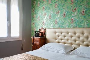 a bedroom with a bed with a floral wallpaper at La Serliana - Bed&Breakfast in Vicenza