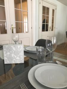 Luxury Apartment T2 - Saldanha في لشبونة: طاولة عليها صحون واكواب للنبيذ
