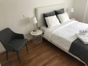 - une chambre avec un grand lit et une chaise dans l'établissement Luxury Apartment T2 - Saldanha, à Lisbonne