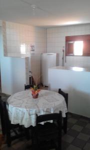 a kitchen with a table and a refrigerator at Amares Apart Hotel in Nísia Floresta