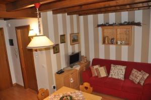 ガッリオにあるAppartamento Altopiano Di Asiagoのリビングルーム(赤いソファ、テレビ付)