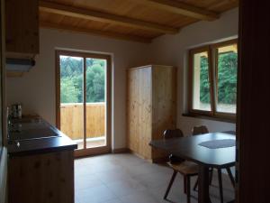 uma cozinha com uma mesa e uma mesa e algumas janelas em Pichlerhof em Bressanone