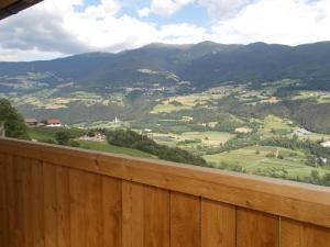 uma vista para um vale a partir de uma cerca de madeira em Pichlerhof em Bressanone