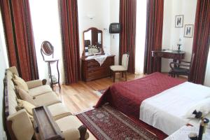 a bedroom with a bed and a chair and a mirror at Hotel Panellinion in Tríkala