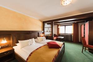 a bedroom with a large bed and a chair at Arlberghaus in Zürs am Arlberg +85 photos