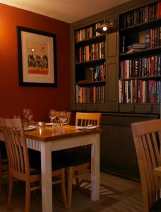 a dining room table with bookshelves and chairs at The North Hill Hotel in Colchester